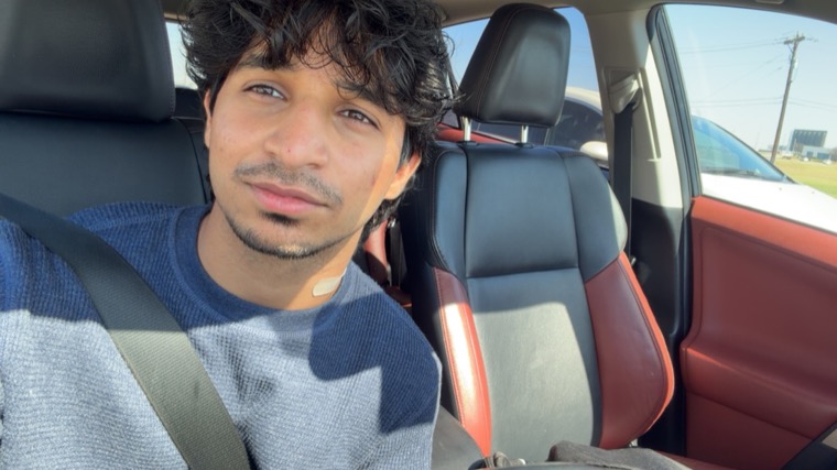 Madhav Suri, a portrait taken in a car on a sunny day